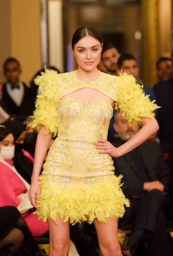 Short yellow evening dress with feather sleeves